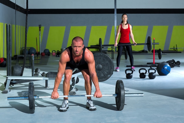 gimnasio con barra de levantamiento de pesas entrenamiento hombre y mujer