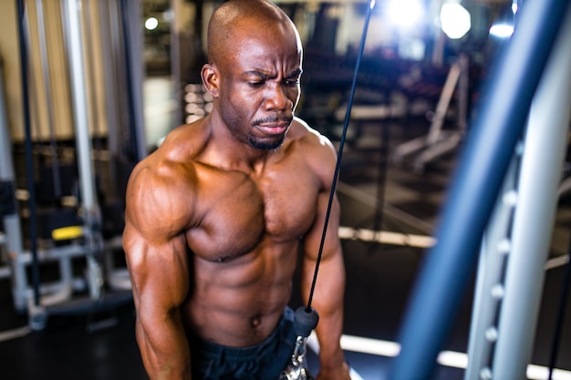 Gimnasio de entrenamiento de brazo de músculos de entrenamiento masculino guapo afroamericano activo