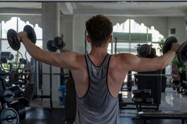 gimnasio de entrenamiento pesado con múltiples equipos trabajando al azar en un gimnasio con un gran músculo fuerte y