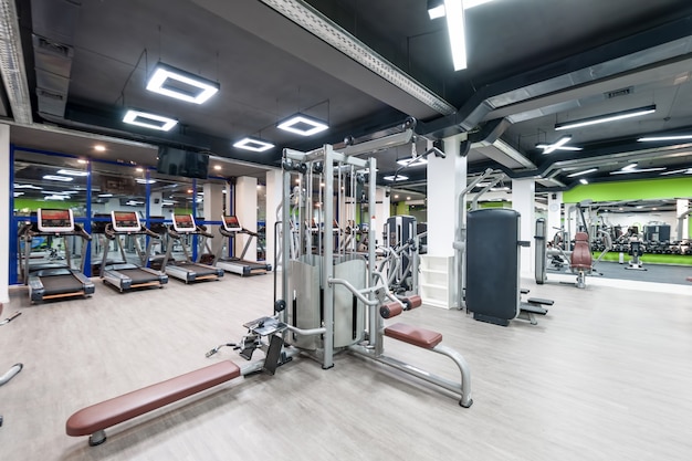 Gimnasio con equipo de ejercicio y techo negro.