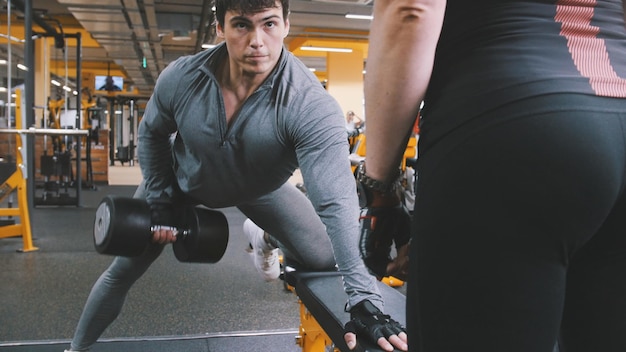En el gimnasio - hombre musculoso atleta levantando pesas