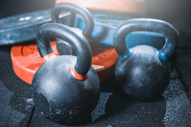 Foto gimnasio. pesas con pesas rusas y barra.