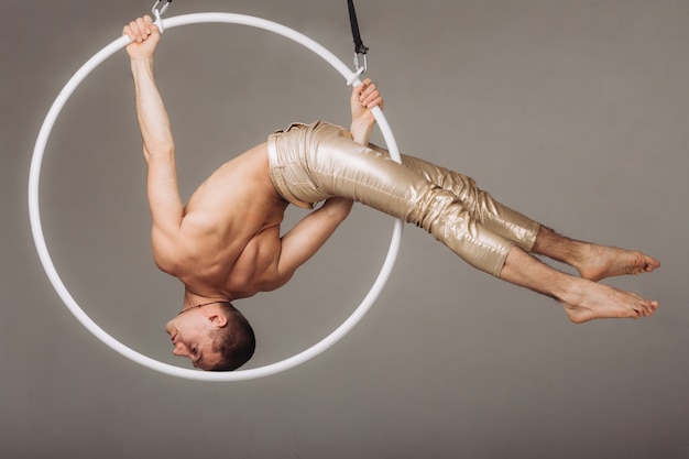 Gimnasta aéreo masculino realiza elemento acrobático en el ring.