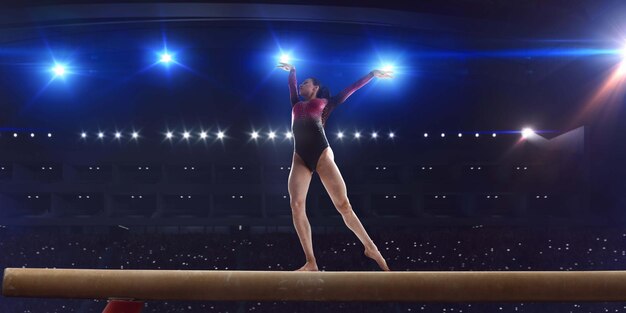 Gimnasta femenina haciendo un truco complicado en la barra de equilibrio de gimnasia en un campo profesional