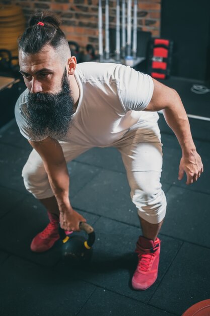 Ginásio. Treinamento de homem barbudo.