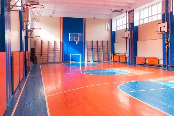 Ginásio vazio no basquete universitário e campo de futebol
