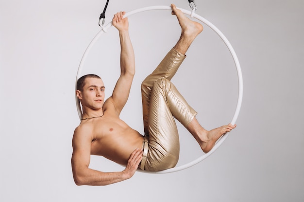 Foto ginasta aérea masculina executa elemento acrobático no ringue