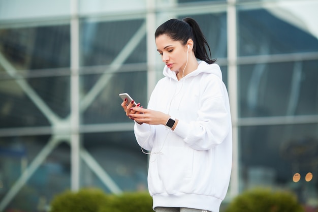 Ginástica. mulher ouvindo música no telefone durante o exercício ao ar livre - esporte e conceito de estilo de vida saudável