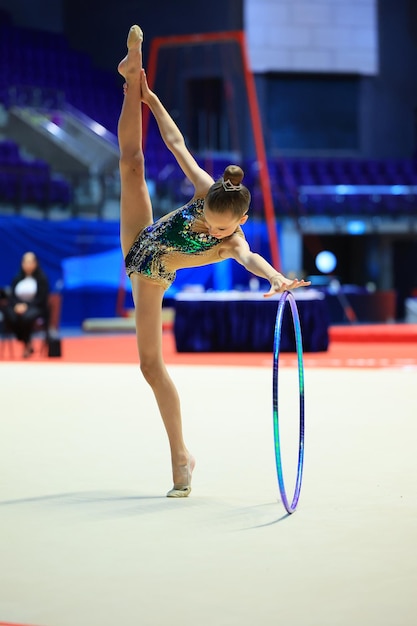 Foto ginástica rítmica na performance da arena profissional com o arco na frente do público alto