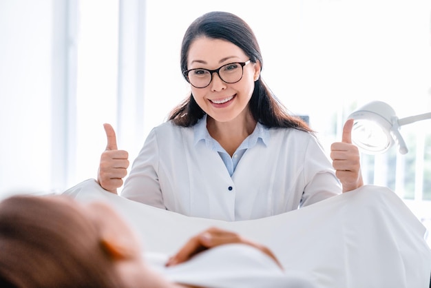 Foto un ginecólogo adulto medio sonriente examina a una mujer en una clínica moderna