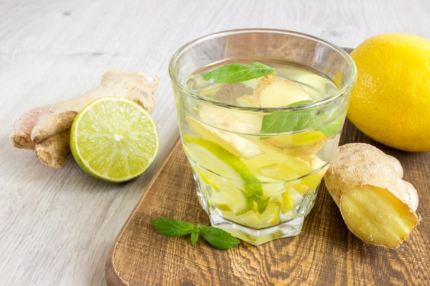 Foto ginger ale soda con jengibre de menta de limón y hielo sobre un fondo de madera rústico