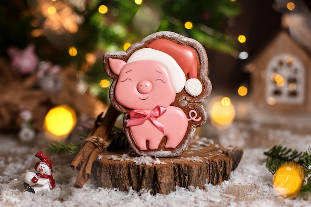 Gingerbread porco rosa feliz no chapéu de Natal em aconchegante decoração quente com luzes garland