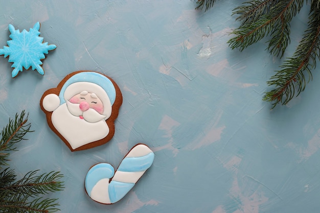 Gingerbreads, Papai Noel, cana e floco de neve em um fundo azul claro, orientação horizontal, espaço de cópia