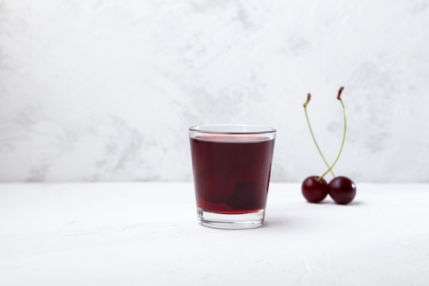 Foto ginjinha o licor portugués ginja elaborado con una infusión de cereza ácida en alcohol aguardente y azúcar.