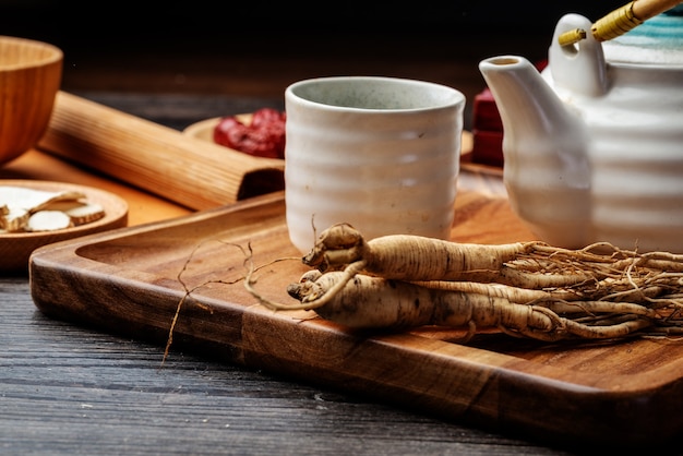 Ginseng und Teetasse stehen auf dem Tisch