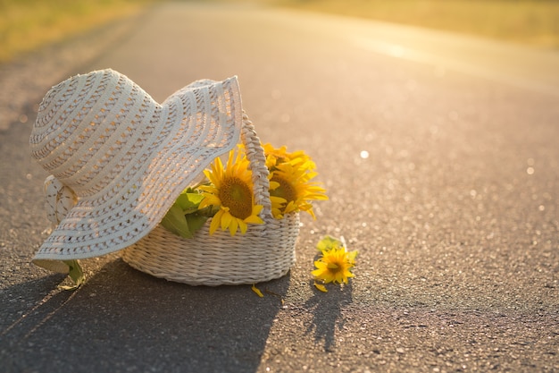 Los girasoles en una canasta yacen sobre el asfalto