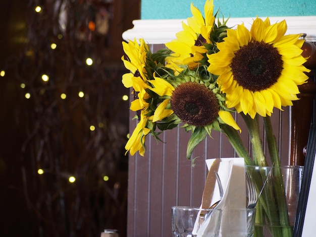 Girasoles en jarrón junto a la pared por la noche