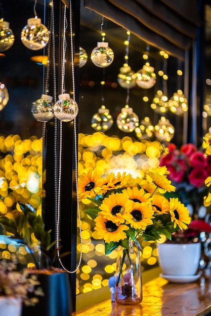 Girassol artificial em vaso de vidro para decoração de luzes de decoração de natal em forma de fundo bokeh decoração durante o natal e o ano novo.