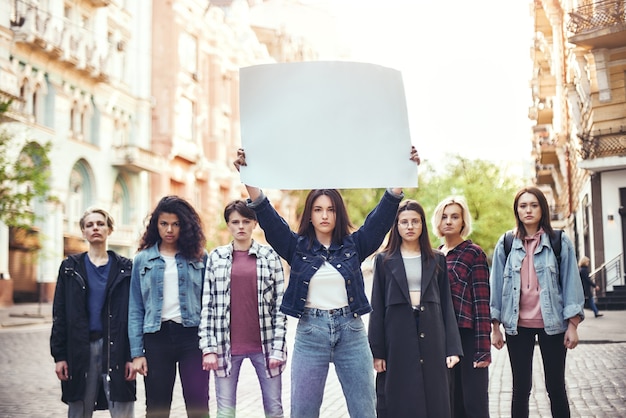 Girl-Power-Gruppe junger Frauen, die während des Protestmarsches junge Frau auf der Straße stehen