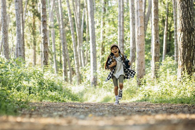 Girl scout corriendo en el bosque