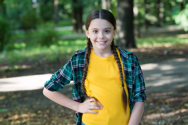 Girl scout lindas trenzas usan ropa a cuadros fondo de naturaleza concepto de campamento de verano