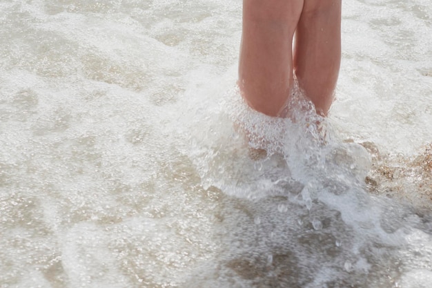 Girl39s piernas en la orilla del mar durante un día soleado de verano Vera España