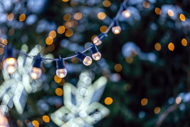 Girlande aus Glühbirnen auf defokussiertem Weihnachtsbeleuchtungshintergrund mit geringer Schärfentiefe und Kopierraum