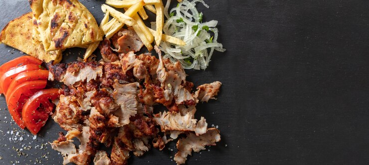 Giro griego comida tradicional de carne en cabeza negra Plato étnico de carne cortada pan pita y tzatziki