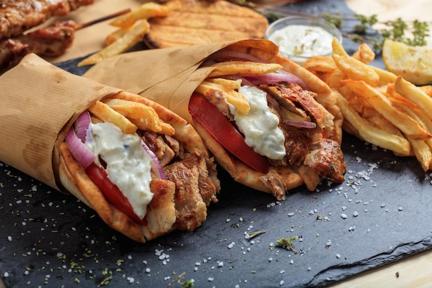 Giroscopios griegos envueltos en pan de pita en un plato negro