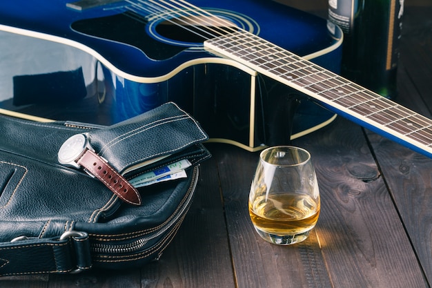 Gitarre und Whisky auf einem Holztisch