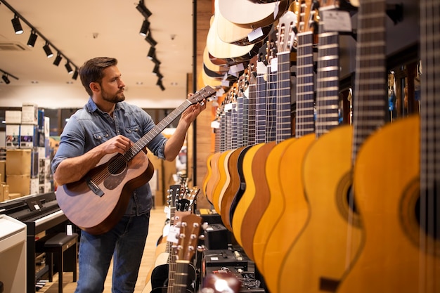 Gitarrenkäufer testet neue Gitarre, die er im Musikgeschäft kaufen will.