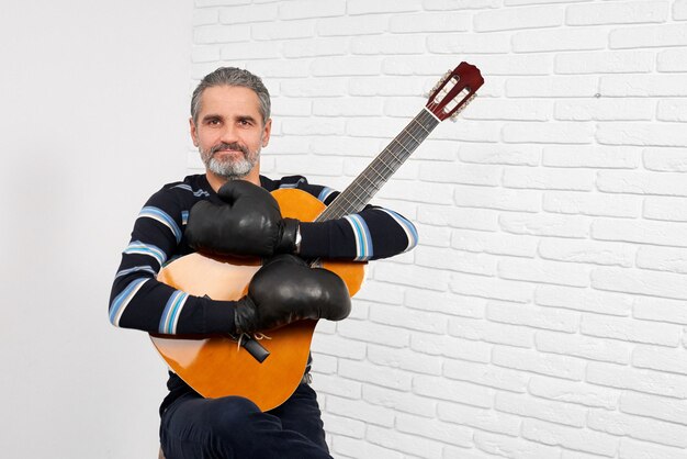 Gitarrist, der bei der Boxhandschuhaufstellung trägt.