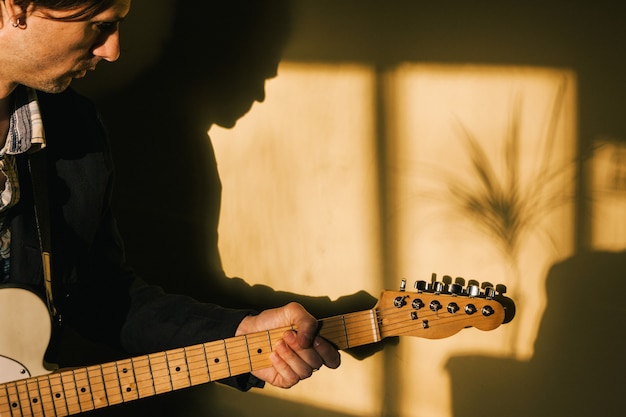 Gitarrist mit E-Gitarre, die zu Hause spielt