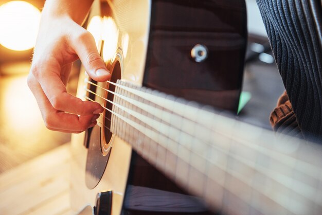 Gitarrist spielt Gitarre auf hölzernem Hintergrund