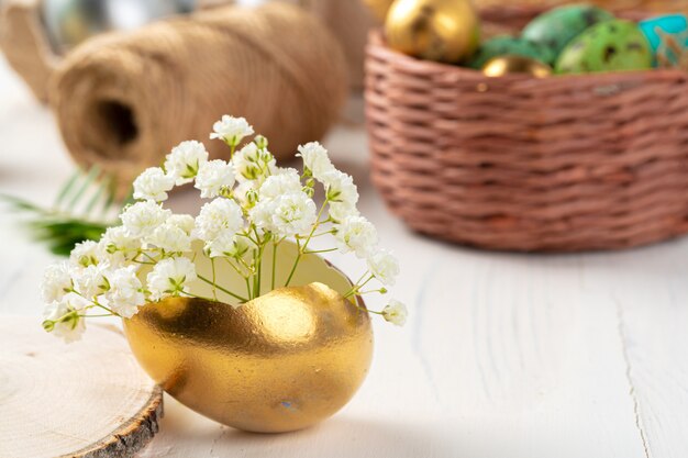 Glänzend golden bemalte Eier mit floralen Zweigen