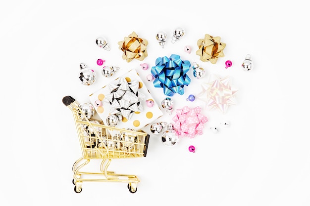 Glänzende Geschenke mit Schleifen in einem Warenkorb auf weißem Hintergrund. Shopping-Konzept. Flache Lage, Ansicht von oben