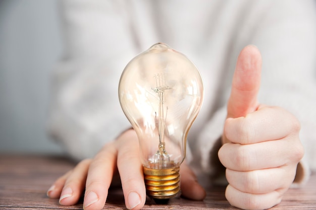 Glänzende Glühbirne mit Daumen hoch, gute Idee und Brainstorming für kreative Geschäfts- oder Bildungskonzepte