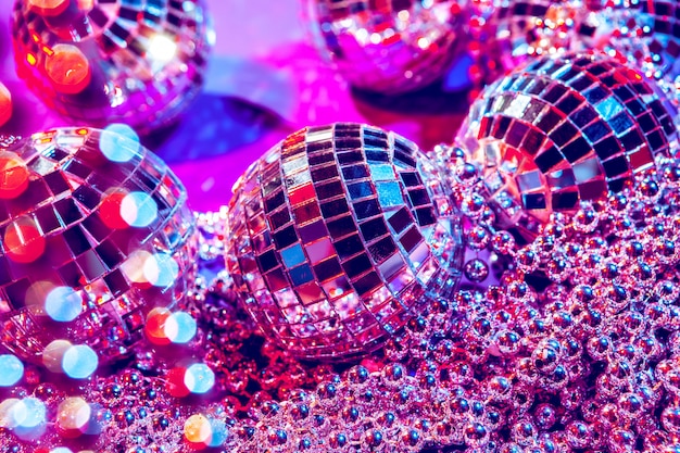 Foto glänzende kleine discokugeln, die in einem schönen purpurroten licht funkeln. disco-party