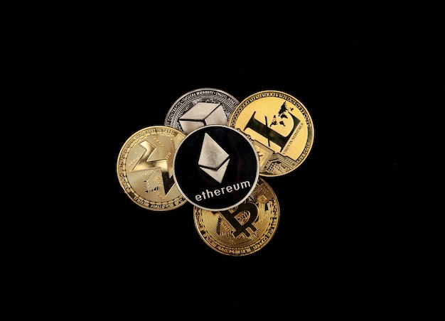 Foto glänzende kryptowährungsmünzen stapeln sich auf schwarzem hintergrund, draufsicht auf ethereum, bitcoin, monero, litecoin.