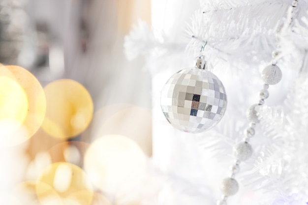 Glänzende silberne Weihnachtskugel auf einem Weihnachtsbaum auf Silber