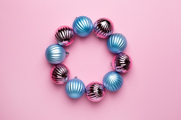 Glänzende weihnachtliche blaue und rosa Kugeln kreisen zur Dekoration auf rosa