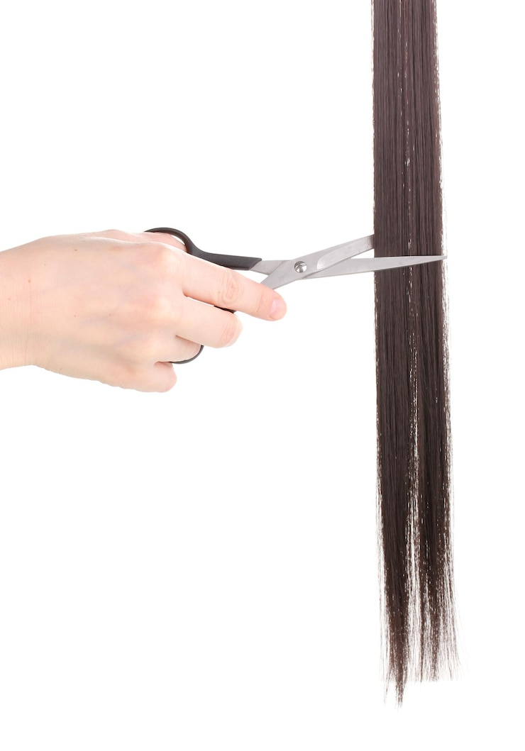 Foto glänzendes braunes haar in den händen des friseurs lokalisiert auf weiß