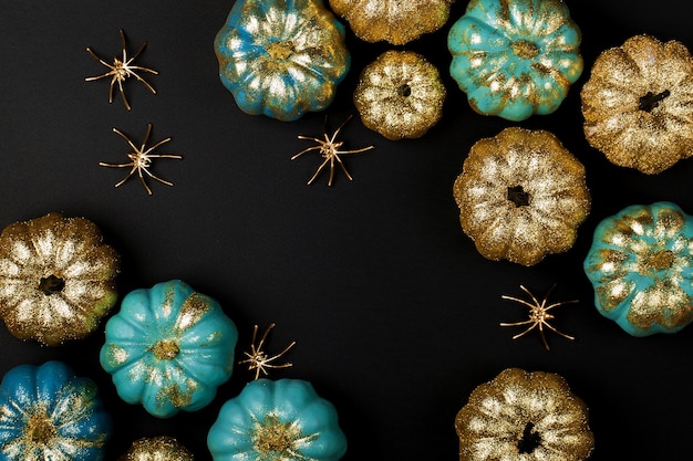 Foto glänzendes gold und blaue kürbisse mit spinnen. halloween-dekorationen. trendiges urlaubskonzept.