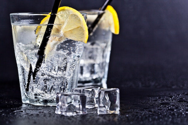 Gläser frisches kaltes Tafelwasser mit Eiswürfeln und Zitronenscheiben
