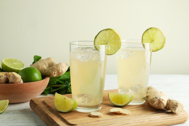 Gläser Ingwerbier und Zutaten auf weißem Holztisch