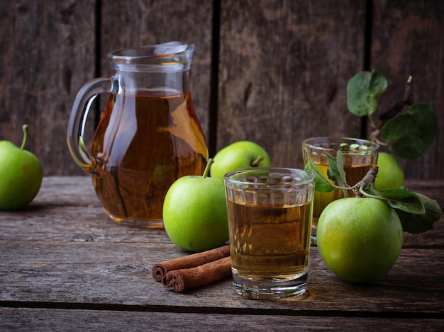 Gläser mit Apfelsaft auf Holztisch. Selektiver Fokus