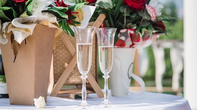 Gläser mit Champagner bei einer Hochzeit auf einem Hintergrund von Blumen 2