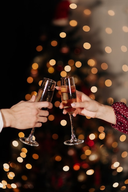 Gläser mit Champagner-Nahaufnahme auf dem Hintergrund der Lichteratmosphäre des neuen Jahres