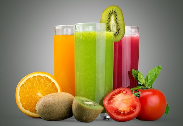 Gläser mit frischem Saft auf hellem Hintergrund