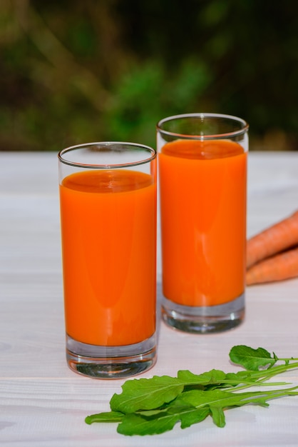 Gläser mit Karottensaft auf einem Holztisch